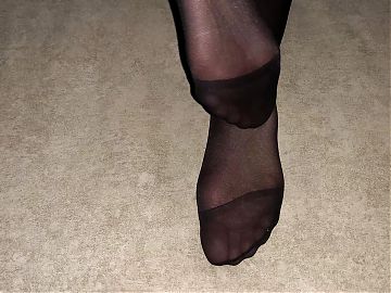 Girl shows her sexy feet in black nylon pantyhose