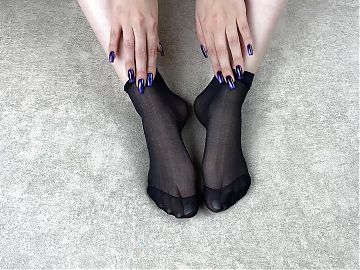 Gloria Gimson in black nylon socks massages her feet